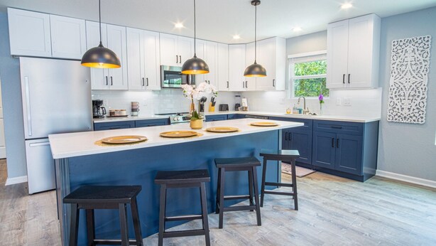 A modern kitchen with a central island, pendant lighting, and bar stools. - Comfortable 4BR 2 5BA Family Home Near Riverwalk (San Antonio)