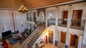 A multi-level living area with a staircase, a chandelier, and a pool table. - Al Karob Yoga Boutique Hotel (Albufeira)