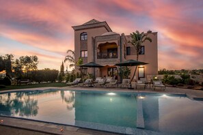 A large, modern house with a swimming pool and outdoor seating area. - Al Karob Yoga Boutique Hotel (Albufeira)