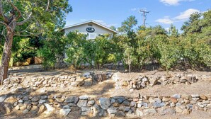 A building with a sign reading "ELIAN CAFE" surrounded by trees and a stone wall. - Julian Cafe Couples Cottage - Breakfast Included at The Julian Cafe & Bakery! (Julian)