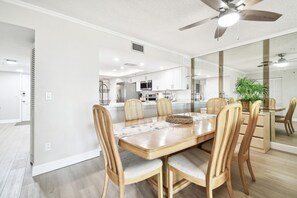 A modern kitchen with white cabinets, a microwave, and a ceiling fan. - Beach Cottages Ocean View Condo (Indian Shores)