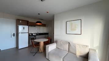 Una cocina moderna con comedor, sofá y una obra de arte enmarcada en la pared.
