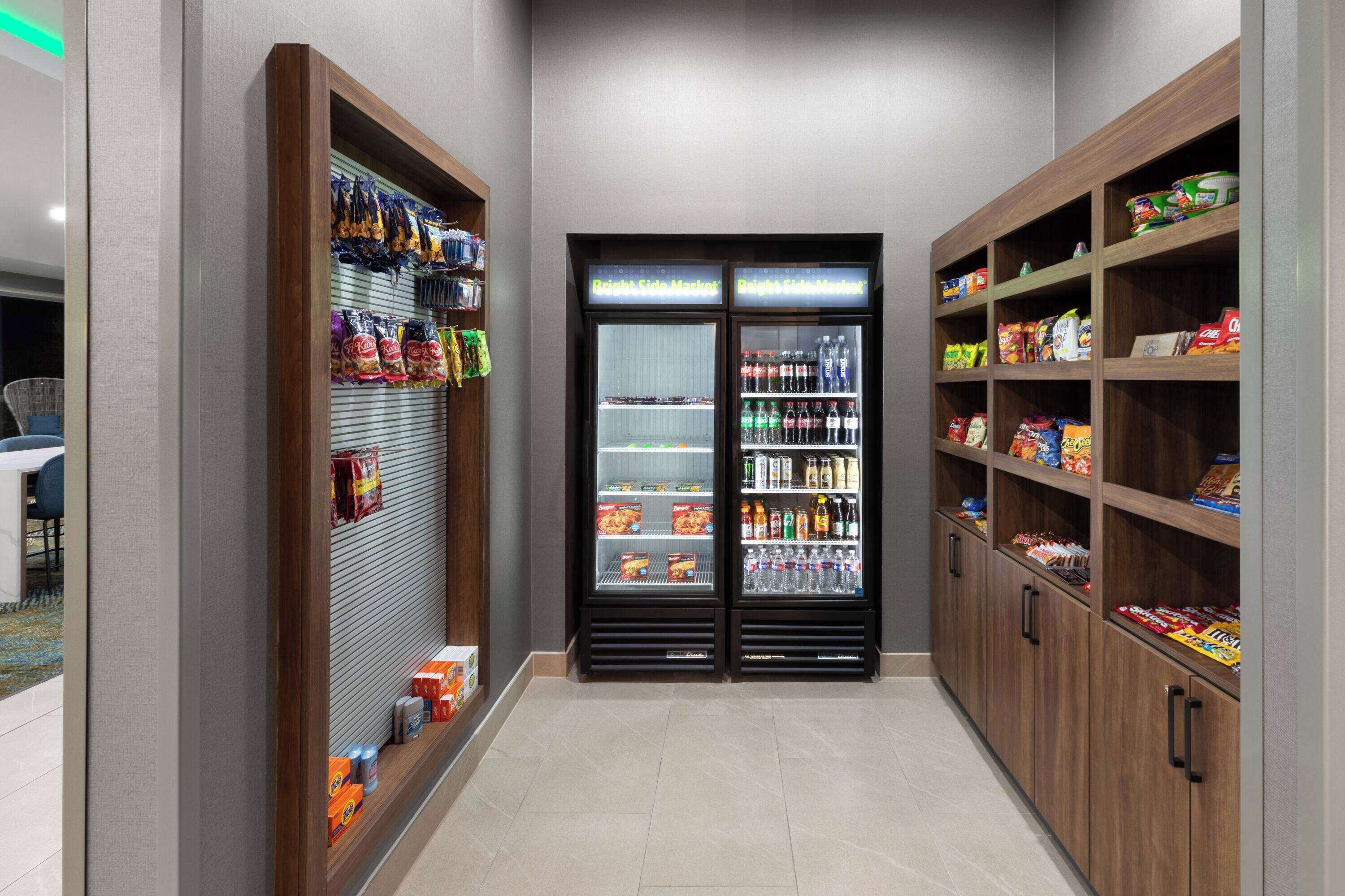 A corridor with snack vending machines and shelves stocked with various food items.