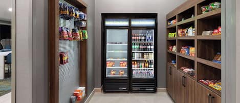 A corridor with snack vending machines and shelves stocked with various food items.