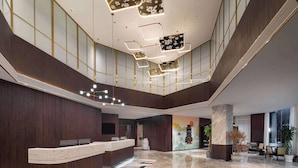 A modern hotel lobby with a reception desk, marble flooring, and a high ceiling with geometric light fixtures. - Days Hotel By Wyndham Nanchang Tengwangge (Nanchang)