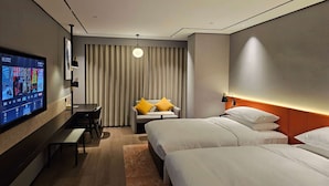A hotel room with two beds, a desk, a TV, and a sofa with cushions. - Days Hotel By Wyndham Nanchang Tengwangge (Nanchang)