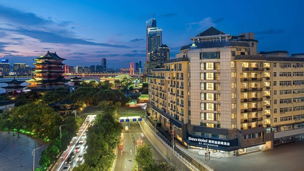 A hotel with a modern design, featuring a prominent entrance and multiple floors. - Days Hotel By Wyndham Nanchang Tengwangge (Nanchang)