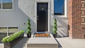 A house with a black front door, number 4, a small porch with a doormat, and two potted plants. - Steps to Hospital and MSU-B| Renovated Hospital Retreat (Billings)