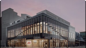 A modern building with a glass facade and signage for Alberta Hair.