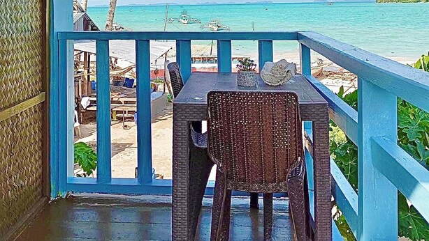 A covered outdoor seating area with a view of the beach and ocean. - Seaside Blue Inn (San Vicente)