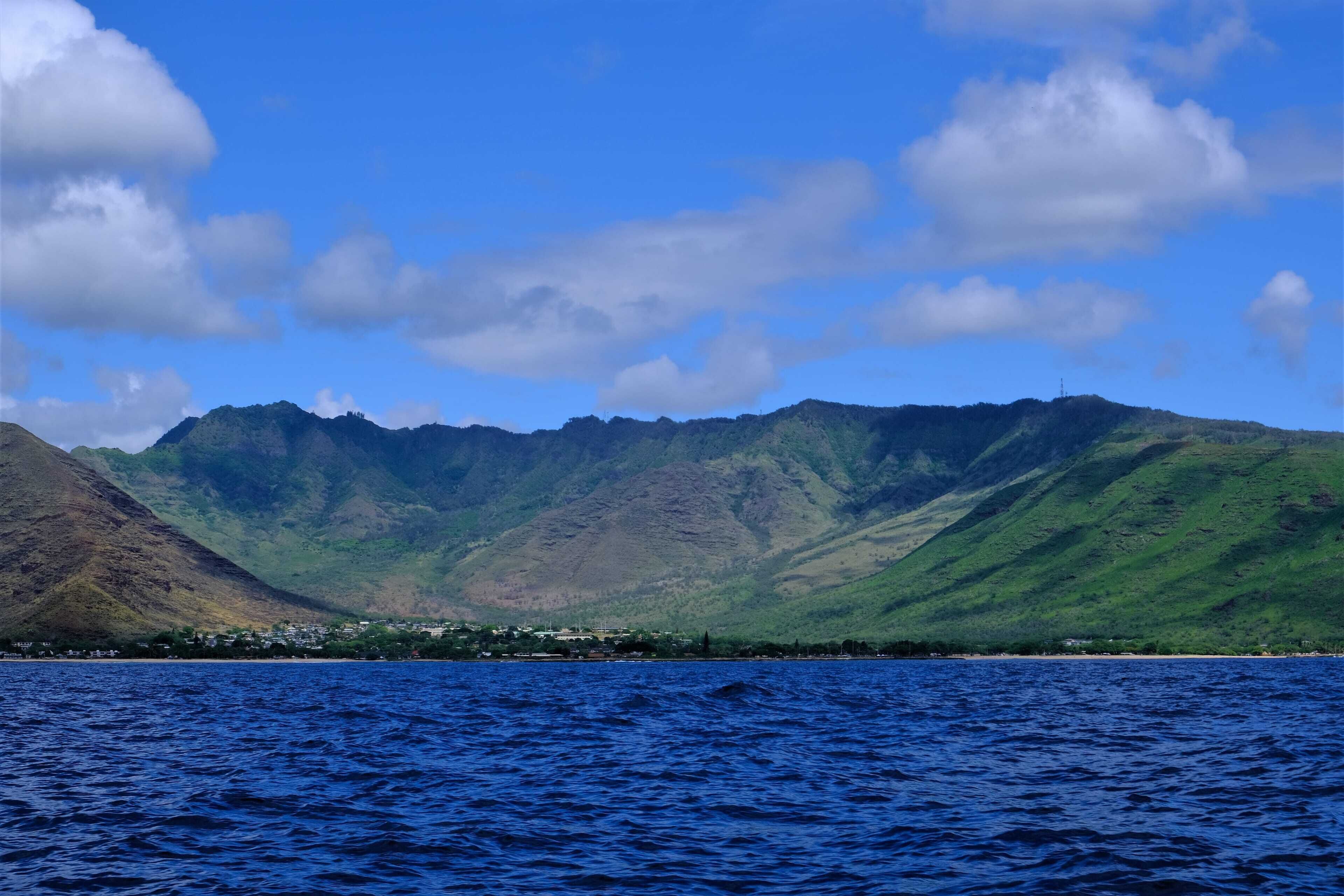 A coastal view with mountains and a clear sky.