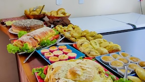 Ein Buffet mit verschiedenen Speisen, darunter Brot, Brötchen und Gebäck.