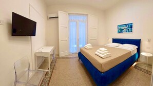 A bedroom with a bed, a desk, a chair, a TV, and a window with curtains. - IDEAL SUITE 41 - SALERNO AMALFI COAST POMPEI NAPLES PAESTUM (Pagani)