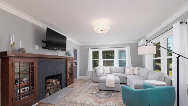 Una sala de estar moderna con chimenea, televisor, sofá y un sillón color turquesa.
