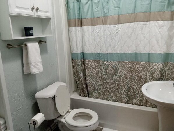 Ein Badezimmer mit Toilette, Waschbecken und Duschvorhang.