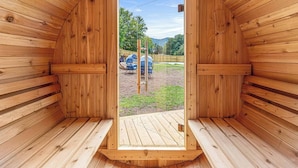 Una sauna de madera con una puerta que da a un espacio exterior.