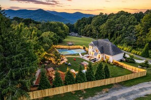 A residential property with a large house, a swimming pool, and a wooden fence. - Fully Fenced Pickleball Asheville Luxury Retreat w/ GameRoom (Swannanoa)