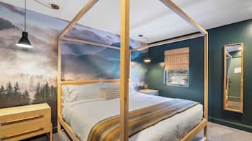 A bedroom with a four-poster bed, wooden nightstands, a wooden dresser, and a large wall mural of a forest.