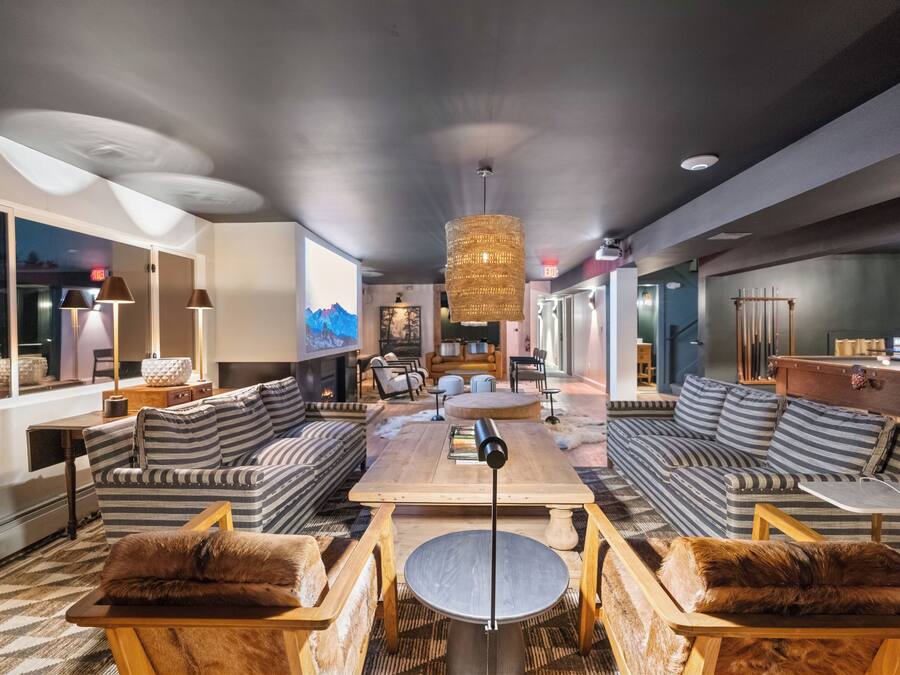 A modern living room with a large sofa, a coffee table, and a fireplace.