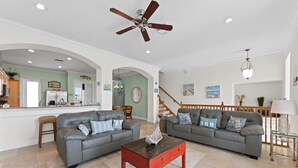 A spacious living room with two grey sofas, a wooden coffee table, and a ceiling fan. - Sunset Views Bradenton Unit A (Bradenton Beach)