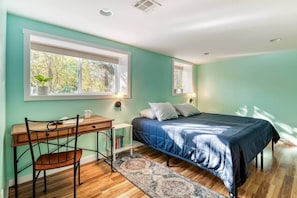 Ein Schlafzimmer mit einem Bett, einem Schreibtisch und einem Stuhl.