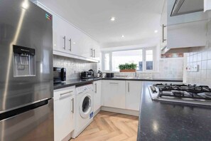 A modern kitchen with stainless steel appliances, a built-in washer, and a gas stove.