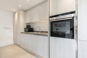 A modern kitchen with stainless steel appliances, a built-in oven, and a microwave.