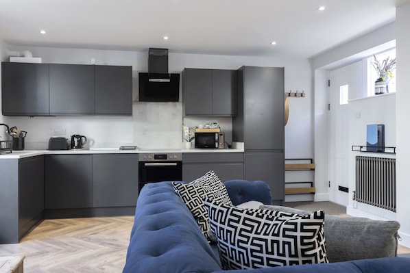 A modern kitchen with dark cabinets, a microwave, and a built-in oven.