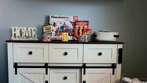 A white cabinet with drawers and a mounted TV.