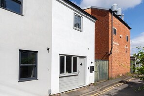 A two-story building with a white facade and a red brick section. - Beautiful Montpellier Retreat (Gloucestershire)