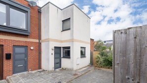A modern two-story residential building with a brick facade and a white upper section. - Peaceful & Spacious 2 Bed Home in Cheltenham (Gloucestershire)