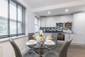 A modern kitchen with white cabinets, a microwave, and a built-in oven.