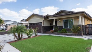 A single-story house with a garage, a front porch, and a well-maintained lawn.