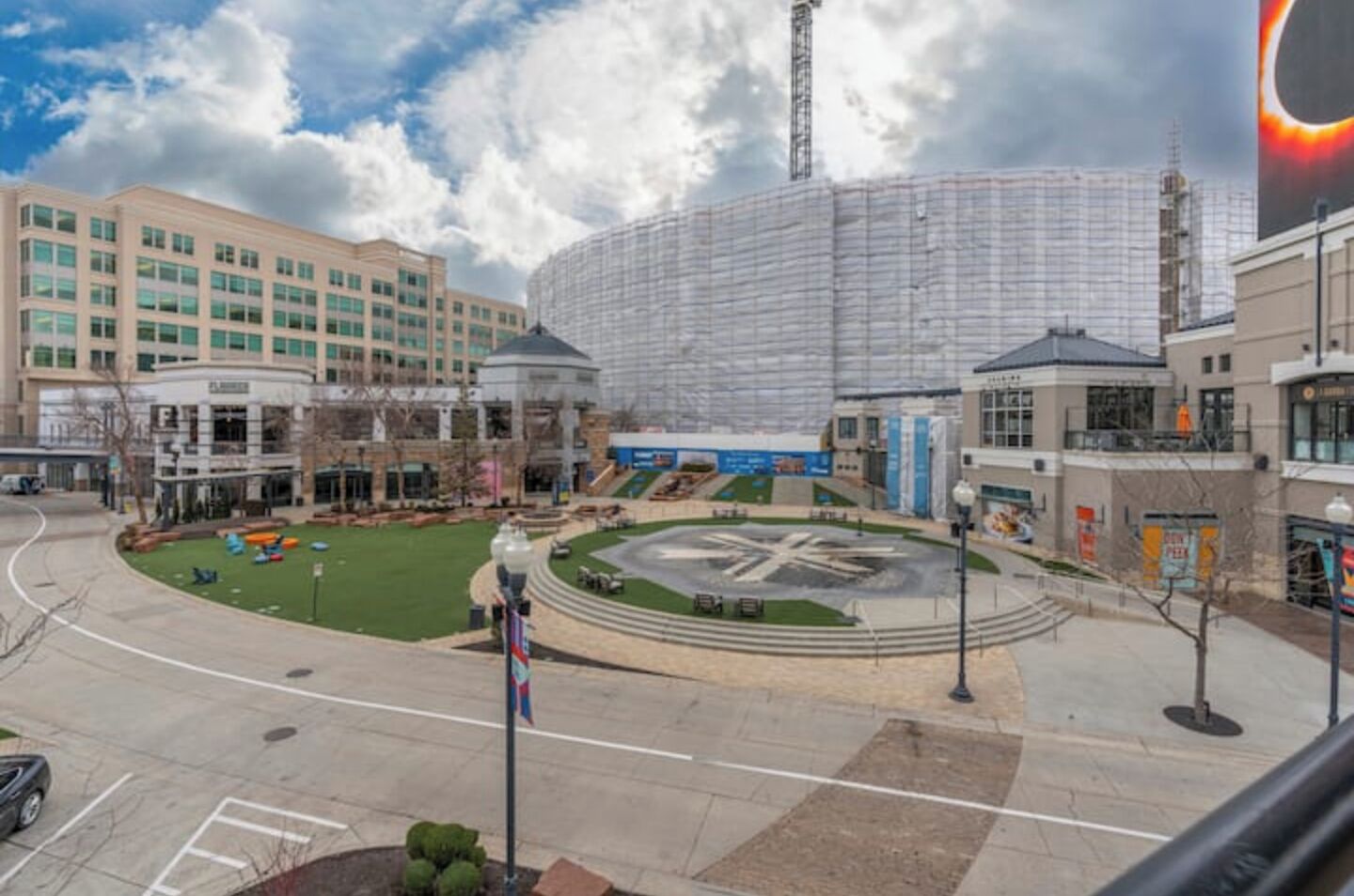 A modern building complex with a central roundabout, a large circular plaza, and a prominent tower structure.