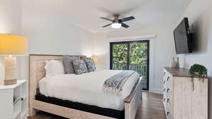 A bedroom with a bed, a ceiling fan, a TV, a dresser, and a window with a view. - Pool | Tennis | Sunset & Seashells | 3 Bedroom | Seagrove (Santa Rosa Beach)