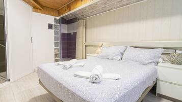 Un dormitorio con una cama grande, una mesita de noche y un armario.