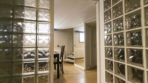 Ein Flur mit Holzboden, einem Esstisch mit Stühlen und einer Treppe, die in eine obere Etage führt.