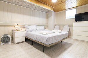 A bedroom with a bed, bedside tables, a fan, and a TV. - ENCANTO CUENCA Espejo Del Rio (Cuenca)