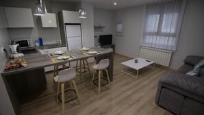 Une cuisine moderne avec un coin repas, une petite table et un canapé.
