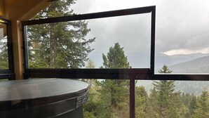 A modern room with a large window overlooking a forested mountain area. - Superior Chalet With Sauna and hot tub (Stadl-Predlitz)