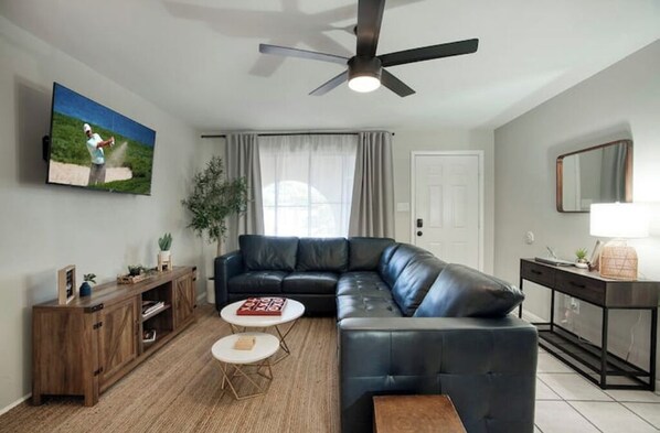 Relax in this inviting living space with a comfortable sofa, coffee table, and large TV.