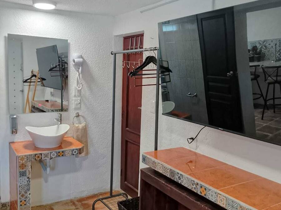 A bathroom with a white sink, a large mirror, and a shower area.