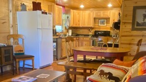 A cozy cabin interior with a dining area, kitchen, and seating space. - Cozy Ranch Apartment, perfect for hunting season, or a fun weekend getaway. (Winnemucca)