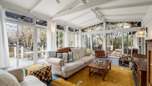 A sunlit room with a sofa, coffee table, and a view of the outdoors.
