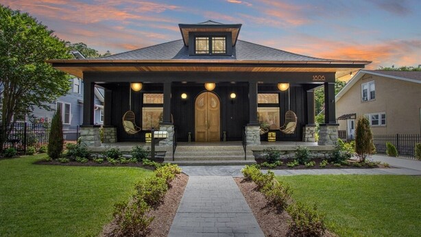 A modern house with a dark facade, a central entrance with a double door, and a stone base. - Beauty on Beech HGTV Featured Designer Home (Nashville)