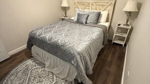 Una camera da letto con un letto, due comodini, un tappeto e una testiera.
