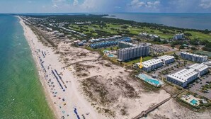 Vista aerea di una zona alberghiera sul lungomare, con accesso diretto alla spiaggia, diversi edifici e una grande piscina.