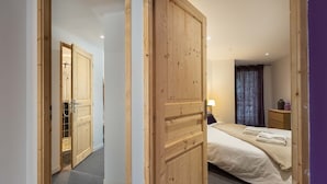 Un dormitorio con cama, mesita de noche, lámpara y armario de madera.