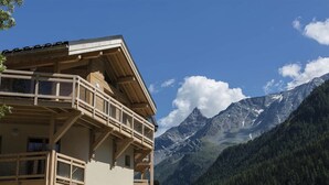 Un chalet doté d’un balcon donnant sur un paysage montagneux.