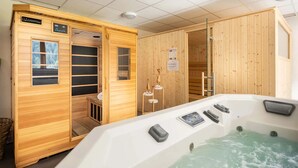 Un sauna avec un intérieur en bois, un jacuzzi et un panneau de commande.